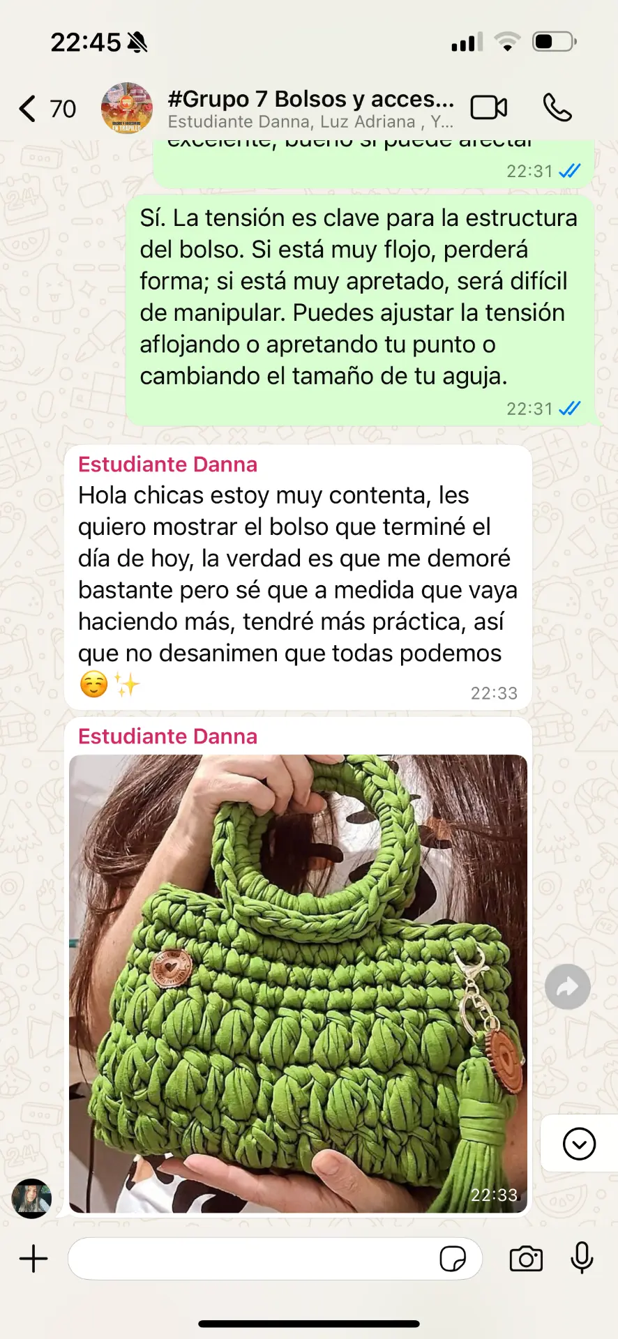 Alumna mostrando su bolso verde tejido en trapillo